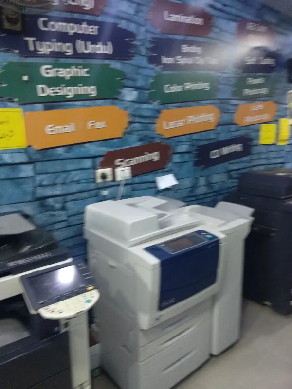 Service signs on the shop wall: typing, graphic designing, scanning, lamination, binding, colour and laser printing